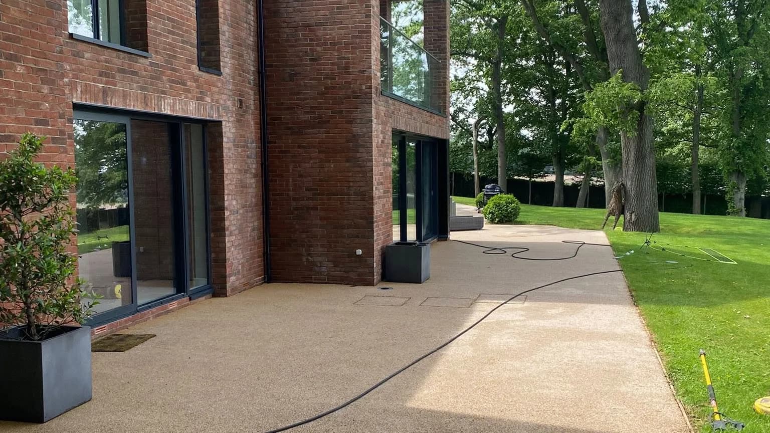 Cleaned exterior paving beside a modern brick property