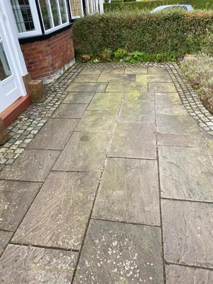 Curved natural-sandstone driveway before cleaning