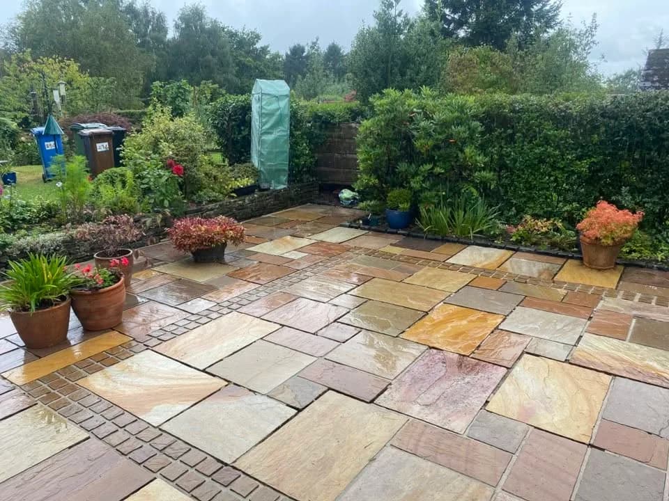 Clean natural-stone patio beside a garden pond