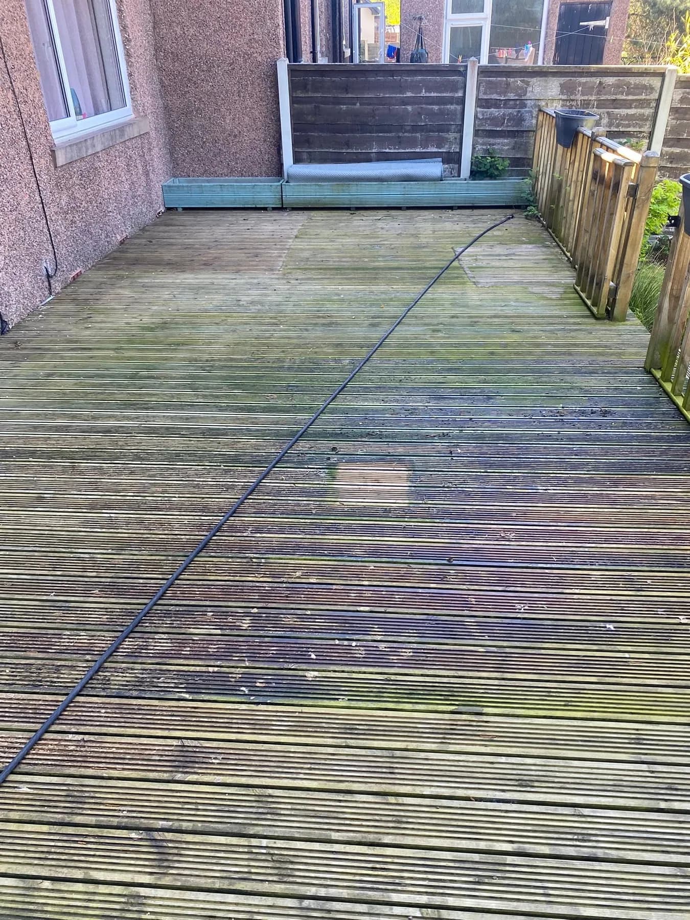 Weathered grooved timber decking before cleaning